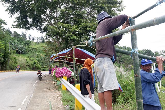 Farmers of Barangay Malubog build makeshift stalls along the highway to display their cut flowers for tomorrow’s All Saints’ Day (CDN PHOTO/TONEE DESPOJO). 
