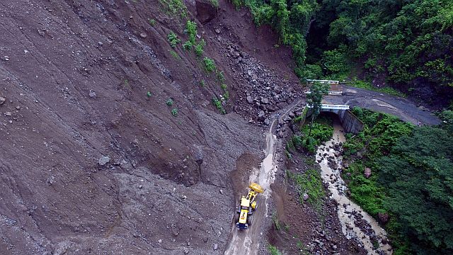  ROAD CLOSED: A road contractor’s heavy equipment arrives to clear the Manipis Road of rocks and loose earth that covered the road link in Barangay Manipis, Talisay City.  Residents said the landslide happened on the evening of  Oct. 8, 2016. 