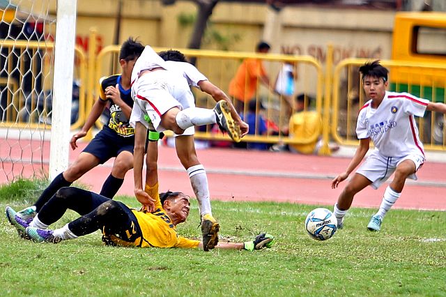 UNDER SIEGE. A fallen USP-F goal keeper valiantly tries to parry the attacks from Ateneo players in this bit of CESAFI secondary boys football semifinal action at the  Cebu City Sports Center field. Ateneo won to make the finals.  (CDN PHOTO/LITO TECSON)