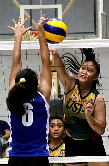 Lyn Rose Denring (7) of the University of San Jose Recoletos (USJ-R) tears the defense being put up by Yanan Julia L. Sanchez (6) of Ateneo de Cebu in Game 2 of the CESAFI secondary girls volleyball finals at the  USC gym. (CDN PHOTO/ JUNJIE MENDOZA)