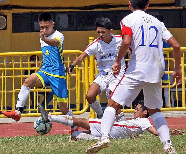 MAD SCRAMBLE. Gicxel Booc (4) of the Don Bosco Technological Center tries to deffend the ball from three SHS-Ateneo de Cebu players during their CESAFI secondary football match at the Cebu City Sports Center field. Don Bosco won, 1-0 to keep its unbeaten mark.  (CDN PHOTO/JUNJIE MENDOZA)