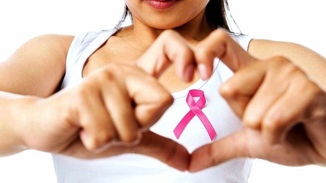 woman-in-tshirt-making-heart-symbol-with-hands-and-pink-ribbon-representing-breast-health-16x9