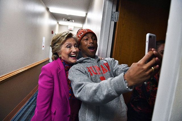 Hillary Clinton poses with singer Pharrell Williams for a selfie backstage before a campaign rally in Raleigh, North Carolina. (AFP)