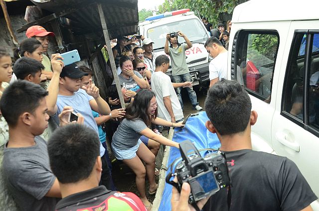 Eighteen-year-old Chesney Espinosa, youngest daughter of slain Albuera Mayor Rolando Espinosa Sr., weeps before the covered body of her father, begging for a hug, as funeral parlor workers carry him out of the Baybay Sub-Provincial Jail. (Photo by Robert Dejon) 