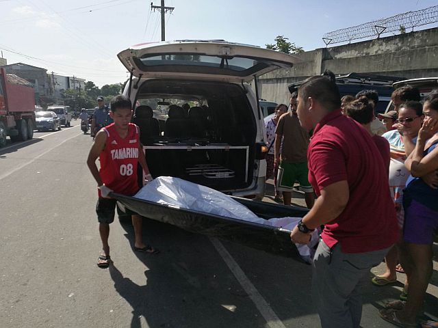 The body of 38-year-old Deddy Batoto carried inside an ambulance (CDN PHOTO/CHRISTIAN MANINGO). 