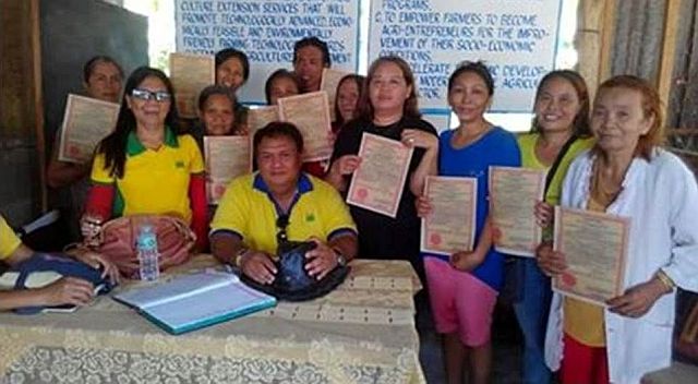 Agrarian reform beneficiaries show the certificates of land ownership award distributed by MARPO Gersyval Vestal and development facilitator Lorna Brigoli (CONTRIBUTED PHOTO). 