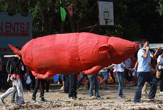 Participants carry a large inasal made of cartoon while waiting for their turn to dance in the Inasal Festival held in Talisay City Central School ground in connection with the City's Fiesta celebration.(CDN PHOTO/JUNJIE MENDOZA)