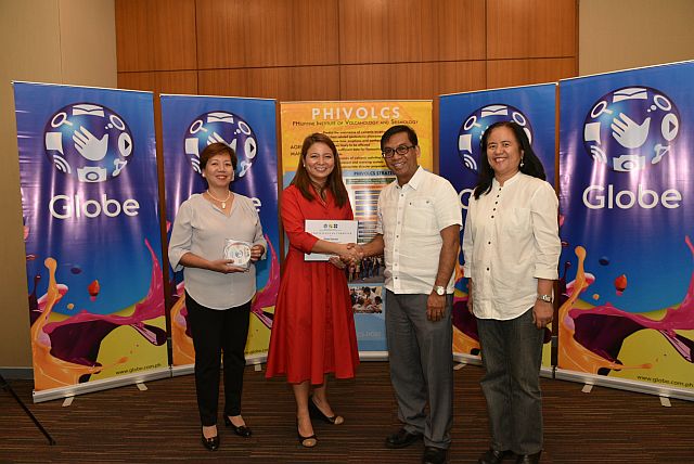 Globe Chief Finance Officer Rizza Maniego-Eala shakes hands with Phivolcs Director Renato Solidum Jr. after the latter turned over Redas hazard data base for 56 provinces. They are joined by Edith Santiago, Globe Head for Logistics and Admin Support, and Dr. Maria Leonila Bautista, project leader for Redas. (Contributed Photo) 