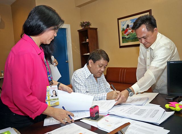 Cebu City Mayor Tomas Osmeña (center) is assisted by City Attorney Joseph Bernaldez (right) in filing a complaint against SM Prime Holdings Inc. at the City Prosecutor’s Office. At left is Aurora Penaflor, Prosecutor II, of the City Prosecutor’s Office. (CDN PHOTO/LITO TECSON)