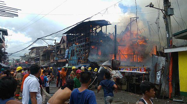 Responding firemen and residents help put out the fire that damaged several houses in Barangay Suba, Cebu City at noon. (CDN PHOTO/LITO TECSON)