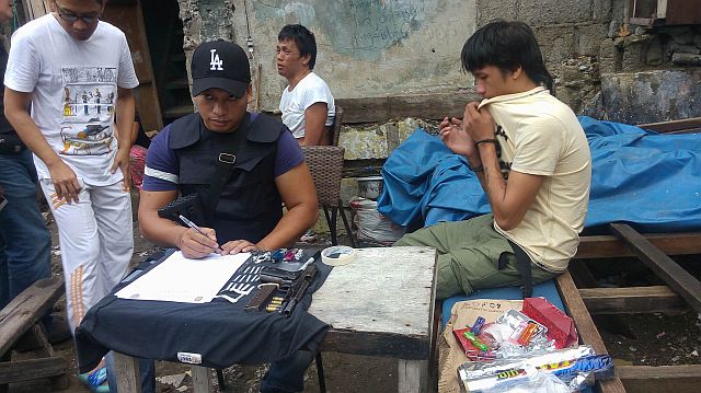 Drug suspect Rewell Villanueva alias 'Peheng' (in white shirt) and his son Francis John (yellow shirt) were arrested by police in Barangay Tejero, Cebu City. (CDN PHOTO/LITO TECSON)
