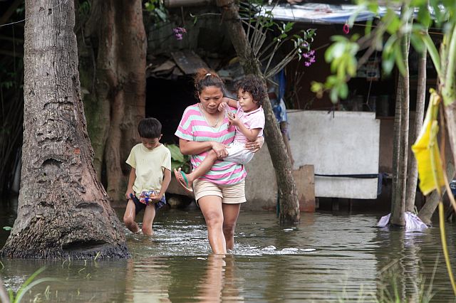 Residents wade in knee-deep water in Sitio Iba, Barangay Basak, Lapu-Lapu City . (CDN PHOTO/ TONEE DESPOJO) 