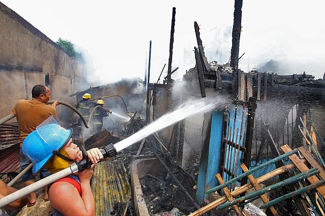 Firefighters (above) battle an afternoon fire in Barangay Pardo, Cebu City. (CDN PHOTO / JUNJIE MENDOZA)