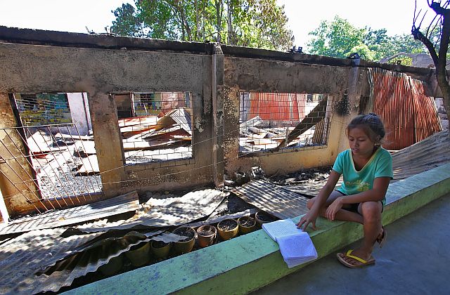 Teachers of Tayud Elementary School in Consolacion town are worried upon seeing their students like Jelian Pobador without classrooms a few hours after last Sunday’s fire (CDN Photos/Junjie Mendoza). 