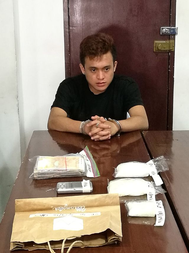 Edwardo Amancio Luzon, 18, is questioned at the Police Regional Office after his arrest in a buy-bust operation in Barangay Labangon in Cebu City. At the table are the suspected shabu confiscated from the suspect (CDN PHOTO/CHRISTIAN MANINGO). 