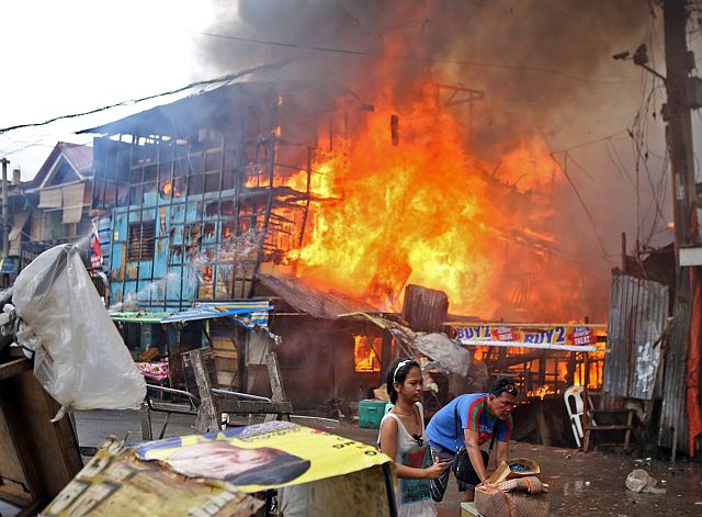 Residents of Barangay Suba flee their homes as fire engulfs another area of the barangay.  Monday’s blaze was second to happen  in Barangay Suba in less than a month (CDN PHOTO/LITO TECSON).