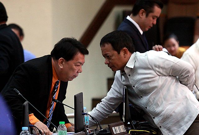 Councilor Joel Garganera of Team Rama confers with  Sisinio Andales of BOPK after the Cebu City council  session on tuesday.  Earlier that day, during a city hall budget hearing, Garganera complained that Team Rama councilors had not been given their phone allowances since assuming office last July. (CDN PHOTO/JUNJIE MENDOZA)