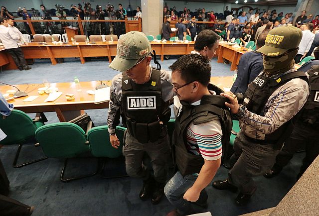 Kerwin Espinosa walked out of the Senate session hall escorted by security forces as the hearing on extrajudicial killings adjourned at the Senate on Wednesday (INQUIRER FILE PHOTO). 