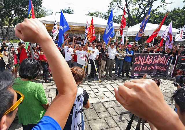 CLASH OF CHANTS. Anti-Marcos protesters  raise their fists as they sing “Bayan Ko” during the rally at Plaza Independencia in Cebu City to object to the burial of Ferdinand Marcos at the Libingan ng mga Bayani. But supporters of President Rodrigo Duterte tried to disrupt their program when they appear on board motorcycles and cars and begin honking their horns and shouting pro-Duterte chants. (CDN PHOTOS/JUNJIE MENDOZA)