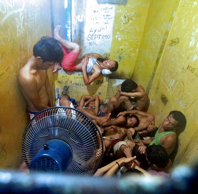 An inmate in one of two detention cells at the Punta Princesa Police Station waits for his turn to sleep. Since the stockade is filled way beyond capacity, inmates have to take turns lying down to sleep (CDN PHOTO/JUNJIE MENDOZA).