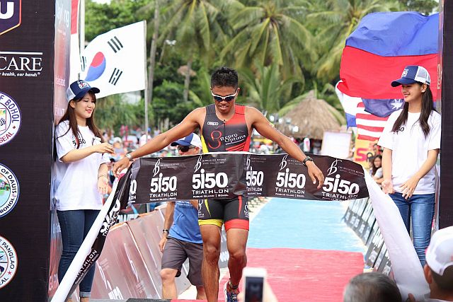 Cebu’s Jorry Ycong crosses the finish line to win the Filipino Elite title of the Bellevue 5i50 Triathlon yesterday in Bohol. (CDN photo/Rab Borbon)