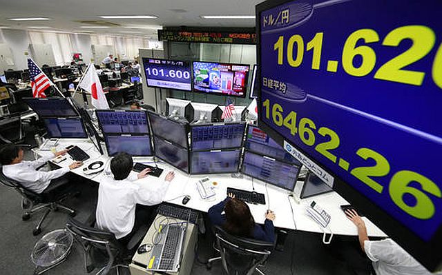 Money traders watch computer screens with the day’s exchange rate between yen and the US dollar at a foreign exchange brokerage in Tokyo, Wednesday (AP). 