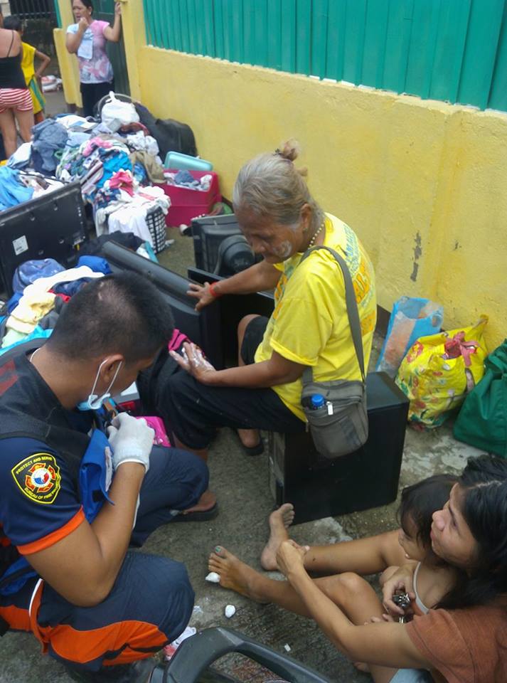 A Bureau of  Fire Protection (BFP) medic personnel attends fire victims who suffer burns when a fire hit Barangay Poblacion Pardo, Cebu City. (CDN PHOTO/ JUNJIE MENDOZA)