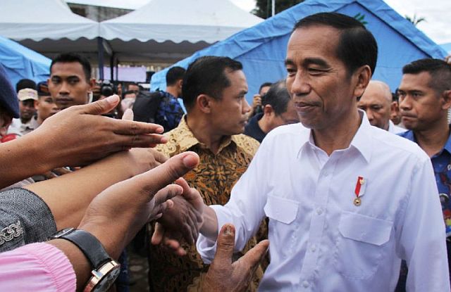  Indonesian President Joko Widodo shakes hands with quake survivors at a temporary shelter in Pidie Jaya, Aceh province (AFP). 