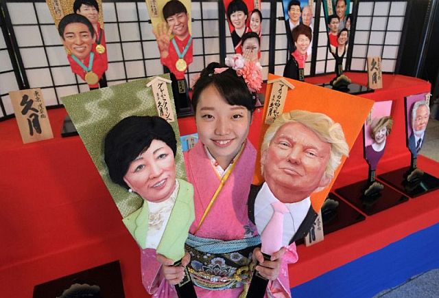  Megumi Kondo, an employee of the Japanese traditional doll-making firm Kyugetsu, displays wooden battledores with the images of US President-elect Donald Trump (right) and Tokyo Governor Yuriko Koike (left) in Tokyo (AFP). 