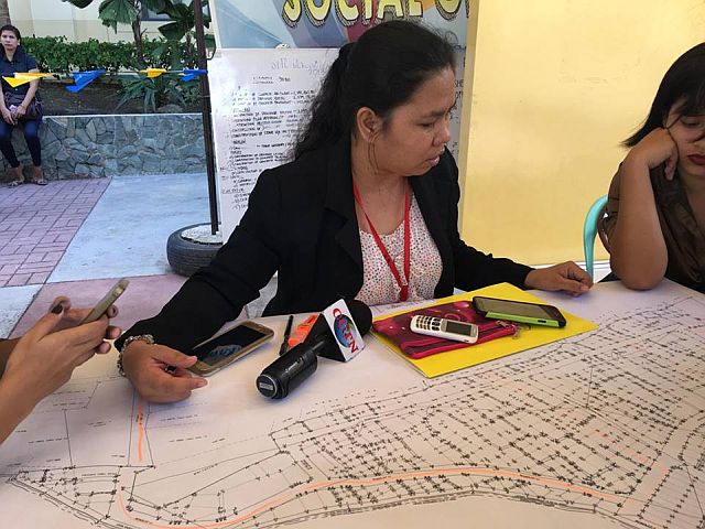 Department for the Welfare of Urban Poor (DWUP) Chief Genevieve Alcoseba shows reporters a map of the fire-stricken area in Barangay Duljo-Fatima. (CDN PHOTO/JOSE SANTINO S. BUNACHITA)