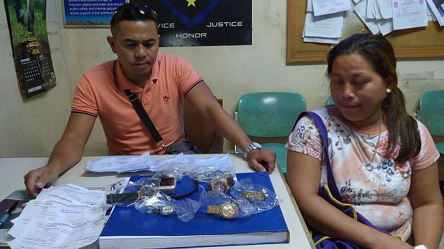 SPO1 Rumualdo Torregosa shows the items they recovered from the house of Archie Ancajas Villaceran, which she stole from her employer, a jewelry reseller, Katheryn Yap. (CDN PHOTO/LITO TECSON)