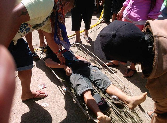 Neighbors help carry the body of Melchor Buling-Buling who was shot dead by motorcycle-riding men in Toledo City on Saturday morning. (CDN PHOTO/RENE F. ALIMA)