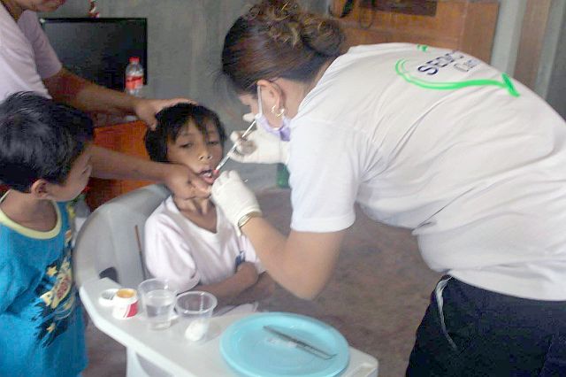 A dentist attends to a patient who availed of free tooth extraction during the medical mission organized by Solid Earth Development Corporation at the Duangan Elementary School in Pinamungahan town. (CONTRIBUTED PHOTO). 