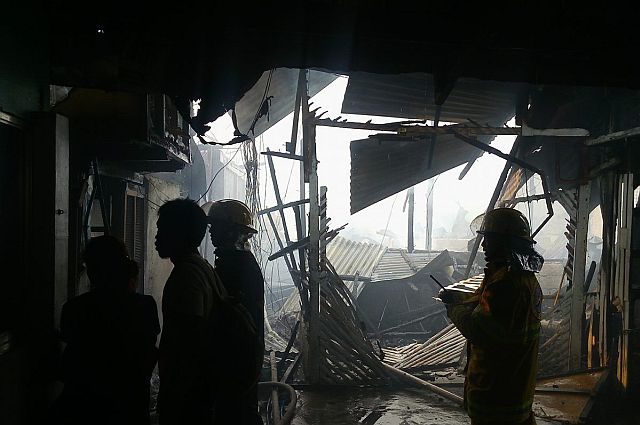Firemen check structures damaged by fire in Barangay Apas, Cebu City. (CDN PHOTO/TONEE DESPOJO)