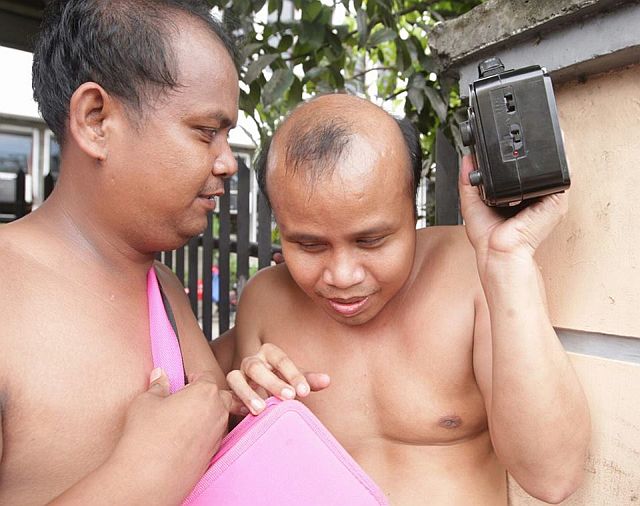 Two blind men checks for updates on the fire through the radio. (CDN PHOTO/TONEE DESPOJO)