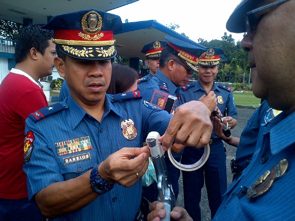 PNP seals firearms muzzle of its policemen to prevent indiscriminate firing during the holiday revelries in this Inquirer file photo. This year however, there will be no muzzle taping as ordered by PNP chief Ronald Dela Rosa.