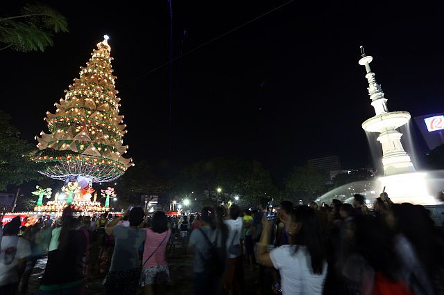 Local and foreign tourists take photos of the 125-foot Christmas tree at the Fuente Osmeña rotunda. The lighting of the giant Christmas Tree of Hope on December  1  officially opens the month-long Pasko sa Sugbo. (CDN PHOTO/JUNJIE MENDOZA)