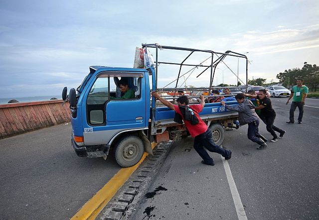 SRP VEHICULAR VEGETABLE TRUCK/DEC.04,2016:CCTO personel push the vegetable truck that was turn turtle in SRP with 8 persons injured after they cleared the street to gave way the traffic.(CDN PHOTO/LITO TECSON)