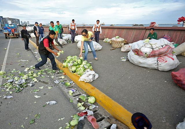 SRP VEHICULAR VEGETABLE TRUCK/DEC.04,2016:CCTO enforcer help clear the road with vegetable after a delivery truck turn turtle hurting his 8 passengers in SRP.(CDN PHOTO/LITO TECSON)