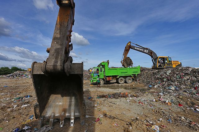 Hauling  equipment of Jomara Konstruckt  continue to clear the SRP garbage  transfer station as of yesterday, Dec. 30, 2016 . But barangay garbage trucks also continue to bring in more trash, replacing those taken out by Jomara. (CDN PHOTO/JUNJIE MENDOZA). 
