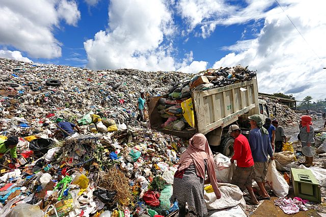 Garbage dump trucks of Cebu City’s Department of Public Services and the mini dump trucks of the barangays still  dump the wastes they collected at the Inayawan landfill until noon of Dec. 17, 2016 despite the closure order of the Court of Appeals. (CDN PHOTO/JUNJIE MENDOZA)