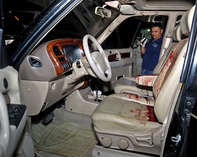 BLOODED CAR. Scene of the Crime Operatives (Soco) personnel check on the vehicle of lawyer Gerik Paderanga, who was shot by a security guard in front of his law firm in Barangay Santa Cruz past 8 p.m. of Dec. 22, 2016. (CDN PHOTO/LITO TECSON)