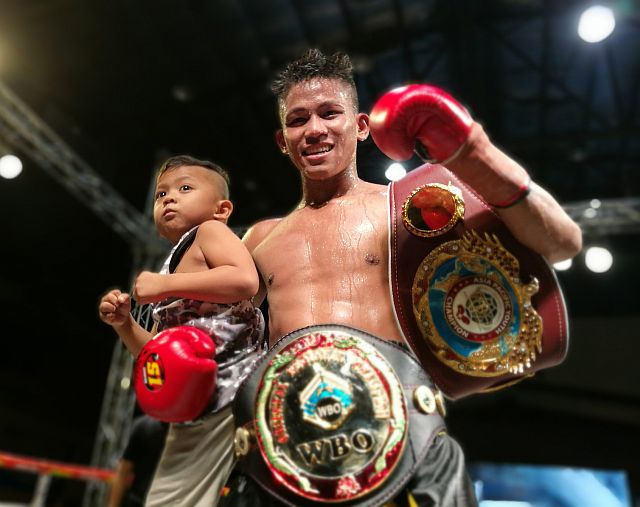 Jhack Tepora clutches his son Aries as he shows off his two WBO regional belts, following his fifth-round technical knockout win over Indonesian Galih Susanto in the main event of “Who’s Next?” Pro-Boxing Series last Friday night at the Mandaue City Cultural and Sports Complex. (CDN PHOTO/CHRISTIAN MANINGO)