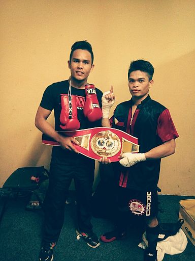 ALA Gym boxer Jonas Sultan (right), together with his trainer Robert Eturma,  shows off the International Boxing Federation (IBF) Intercontinental Super flyweight belt that he stole from Makazole Tete via a second-round stoppage in East London, Eastern Cape, South Africa. (CONTRIBUTED PHOTO)