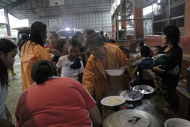 Evacuees of Barangay Paknaan receive cooked meals from City Hall social welfare personnel prior to returning to their homes. (MANDAUE PIO FACEBOOK PAGE)