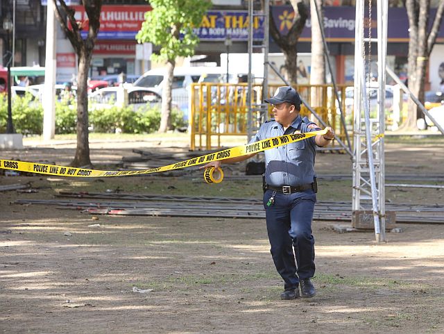 A policeman isolates an area with yellow tape containing the words 'Police Line Do Not Cross' during a bomb simulation drill held at Fuente Osmeña (CDN PHOTO/LITO TECSON). 