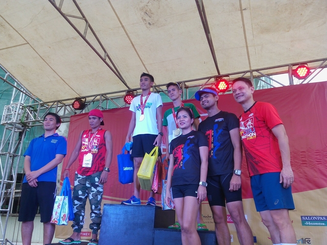 42k champion Rafael Pescos (top of the podium) along with second placer Jeson Agravante (right side of the podium) and Maclin Sadia (left side of the podium) were flanked by the organizers of the 10th Cebu City Marathon during the awarding ceremonies (CDN PHOTO/GLENDALE ROSAL).