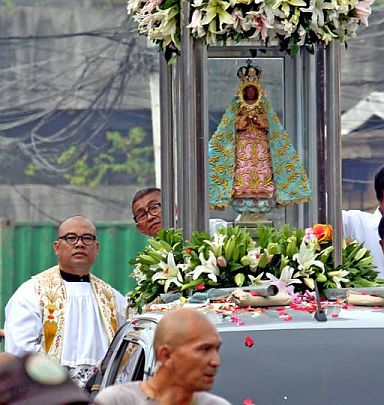 Fr. Romeo Desuyo accompanies his image of the Our Lady of Guadalupe during the Traslacion motorcade on Friday morning. The new image is shorter than the icon used in previous years.(CDN PHOTO/JUNJIE MENDOZA). 