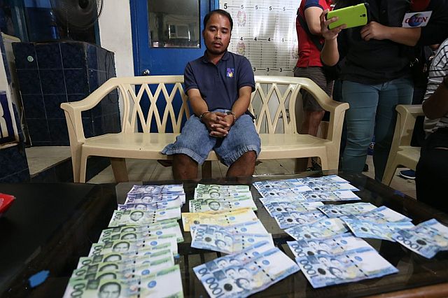 Junrey Cagay, 28, was arrested by police for allegedly manufacturing fake peso bills along Colon Street in Cebu City. (CDN PHOTO/JUNJIE MENDOZA)