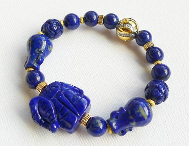 Royal Lapis Lazuli bracelet with  10k gold charms and lucky feng shui charms (made of lapis lazuli  also): elephant for wisdom and strength, lotus flowers for harmony and peace, and wealth jars  to steer in good luck,  ortune and wealth.